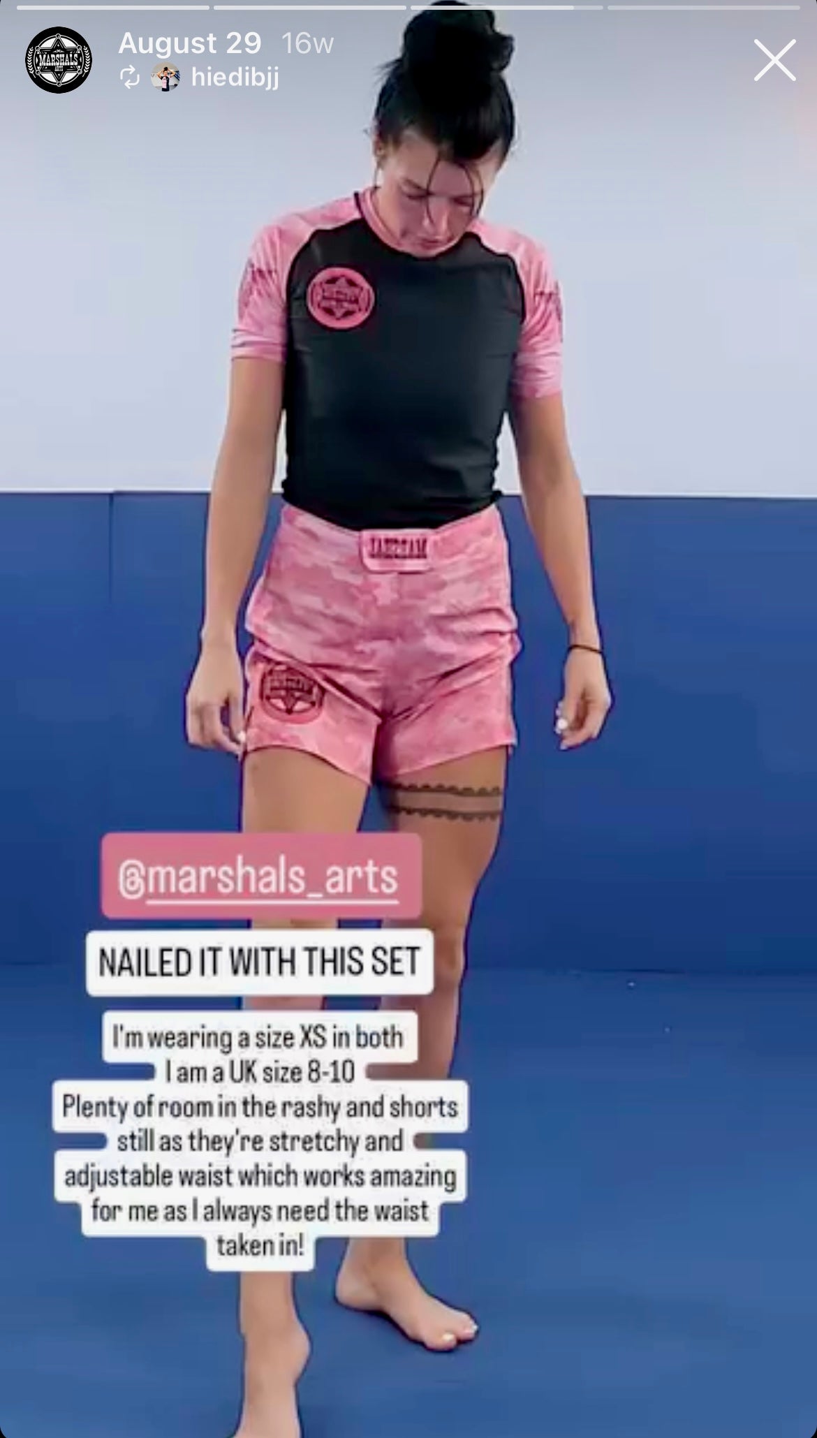 “Instagram screenshot of a female influencer wearing the pink camo rashguard and shorts kit, discussing her size choices and highlighting the shorts’ stretchiness and snug waist fit for Jiu-Jitsu and training.”